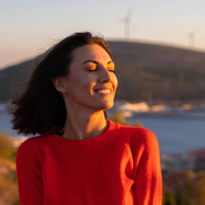 Woman outside, looking up with her eyes closed for therapy for women
